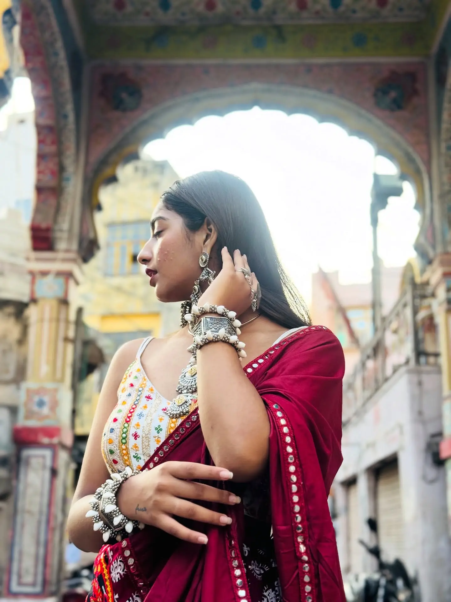 Vanshika Tanwani in a red Navratri chaniya choli with oxidised silver jewellery under a painted arch