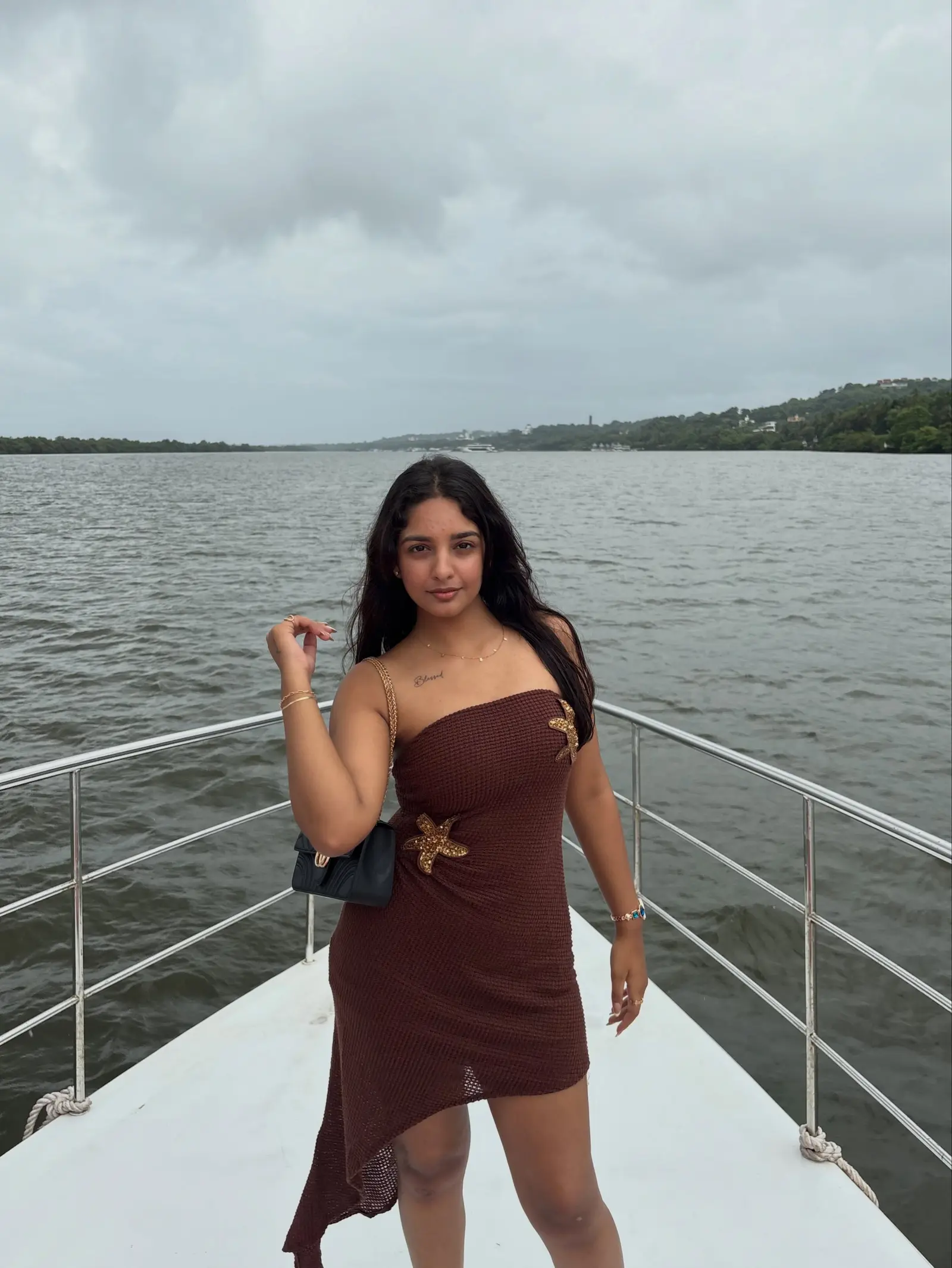 Vanshika Tanwani in a brown strapless dress on a boat deck