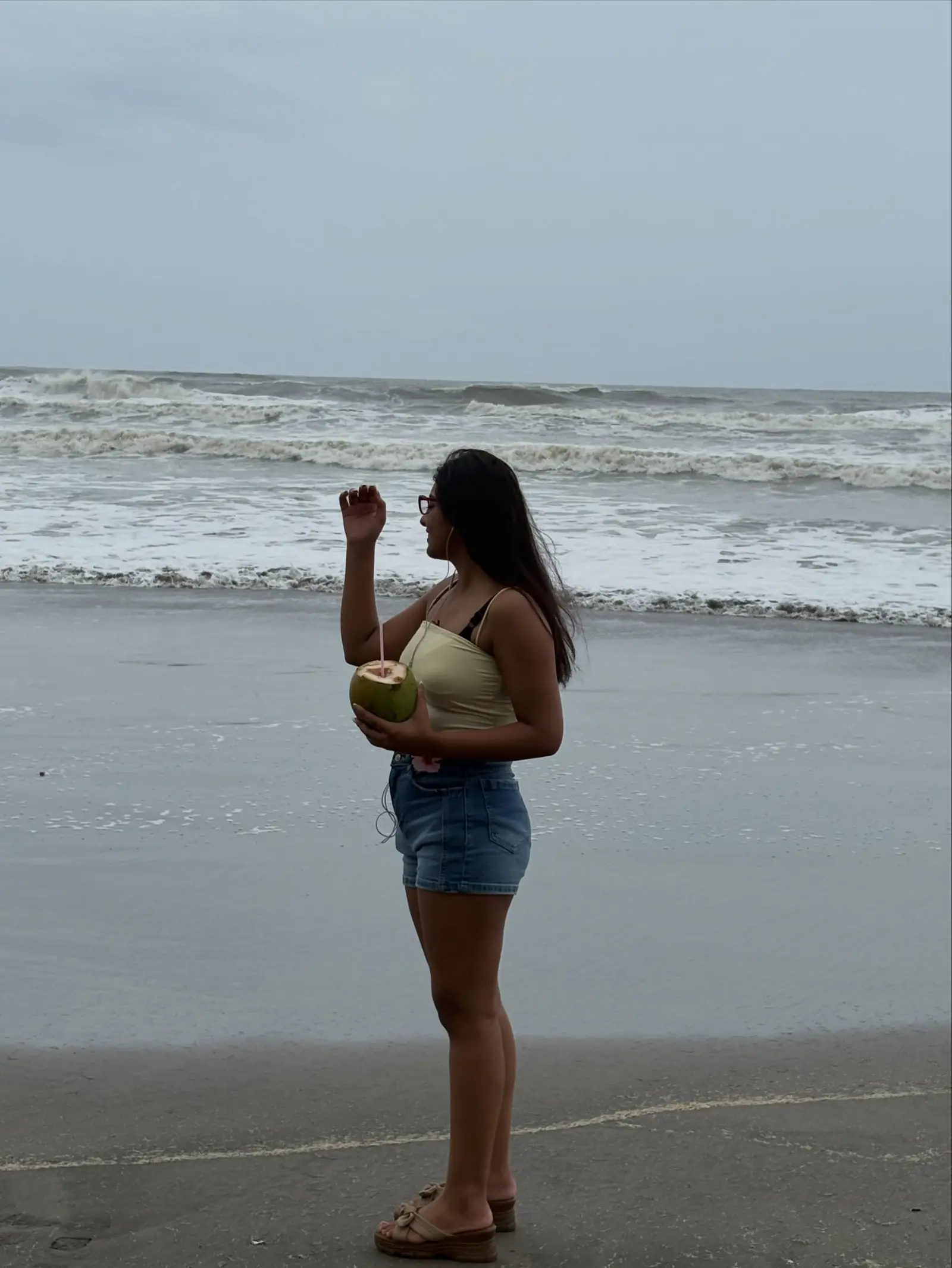 Vanshika Tanwani holding a coconut on a monsoon beach in North Goa